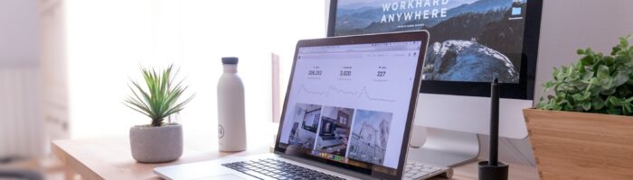 MacBook Pro on table beside white iMac and Magic Mouse