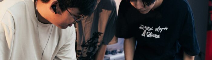 Two people looking at something in a person's hand.